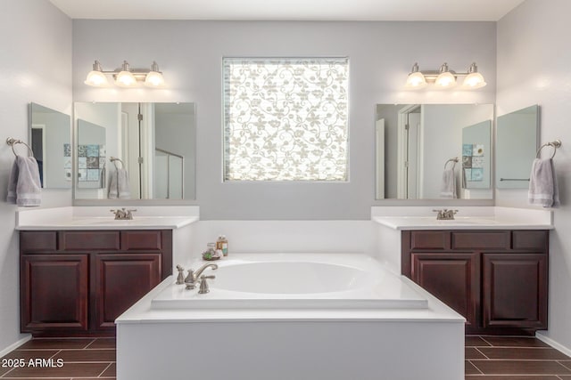 bathroom with a garden tub, wood tiled floors, two vanities, and a shower with door