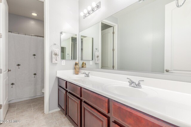 full bath with toilet, double vanity, a shower with shower curtain, and baseboards