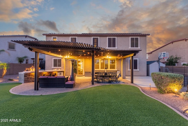 back of house at dusk featuring a pergola, stucco siding, a patio, and an outdoor living space with a fire pit