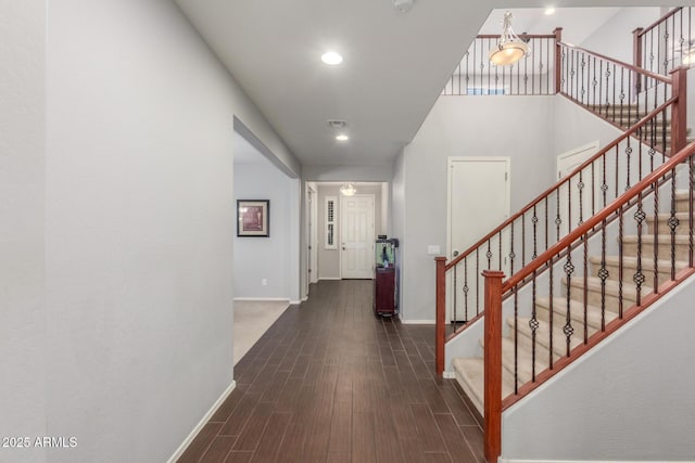 corridor with baseboards, dark wood-type flooring, recessed lighting, and stairway