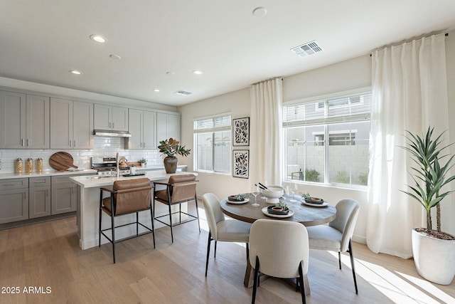 dining room with light wood finished floors, recessed lighting, and baseboards