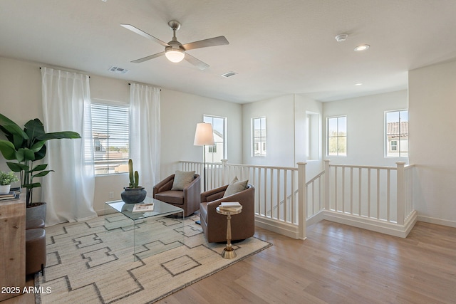 sitting room featuring an upstairs landing, wood finished floors, plenty of natural light, and recessed lighting