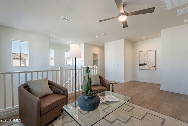 living area featuring wood finished floors, ceiling fan, baseboards, and recessed lighting