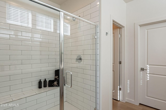 bathroom with a stall shower and wood finished floors