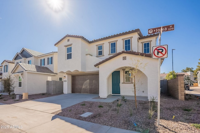 view of front of house with stucco siding, an attached garage, a tiled roof, driveway, and fence