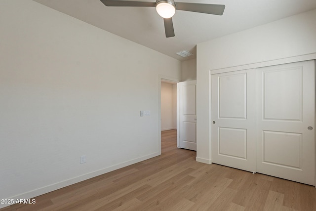 unfurnished bedroom featuring light wood-style flooring, a closet, baseboards, and a ceiling fan
