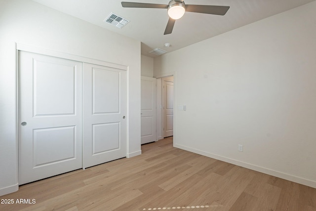 unfurnished bedroom with light wood-style floors, a closet, baseboards, and ceiling fan