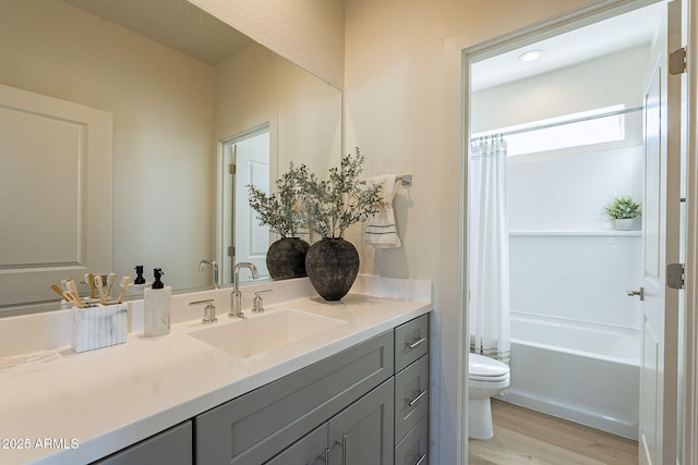 full bathroom with toilet, wood finished floors, vanity, and shower / bath combo