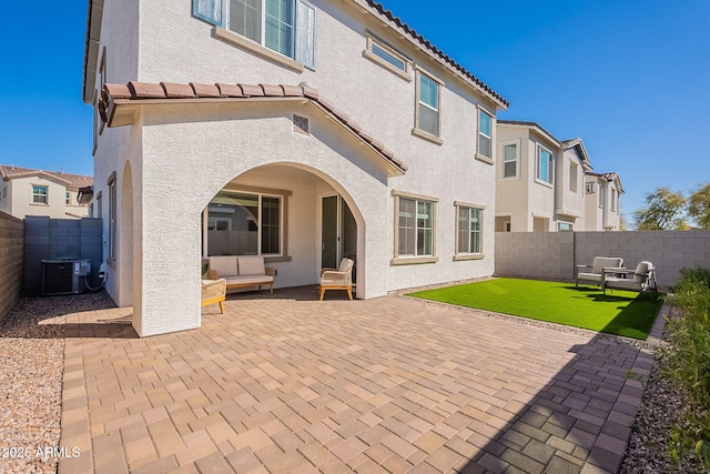 back of property with a patio, stucco siding, central AC, and a tile roof