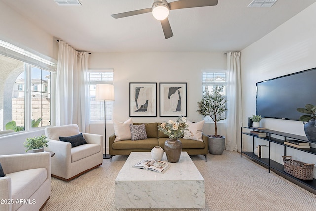 living room featuring a ceiling fan, plenty of natural light, and light carpet
