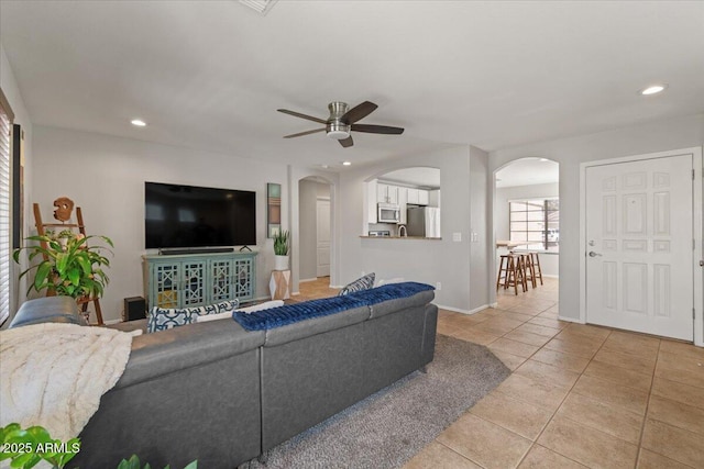 1703 E Palo Blanco Way, Gilbert, AZ 85296 - living area with arched walkways, light tile patterned floors, ceiling fan, recessed lighting, and baseboards
