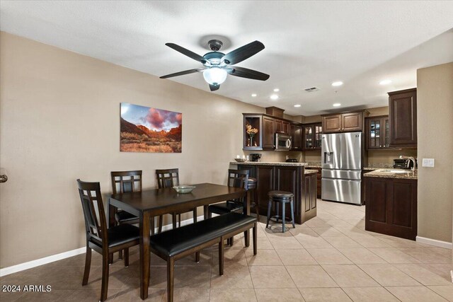 dining room featuring light tile patterned floors, ceiling fan, and sink