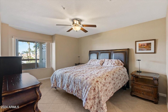 tiled bedroom with ceiling fan and a textured ceiling