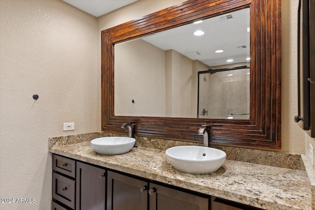 bathroom featuring vanity and a shower with door