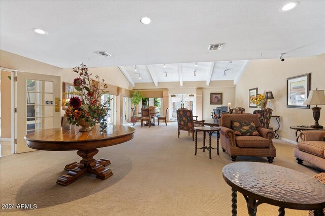 carpeted living room featuring wooden ceiling, french doors, and lofted ceiling with beams