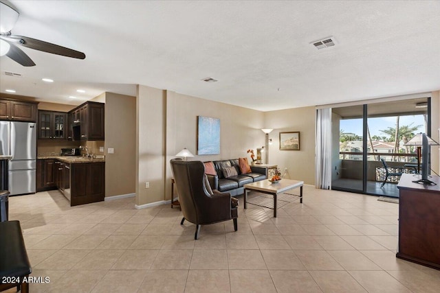 living room with ceiling fan, sink, and light tile patterned flooring