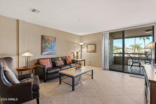 living room featuring expansive windows, light tile patterned flooring, and a textured ceiling