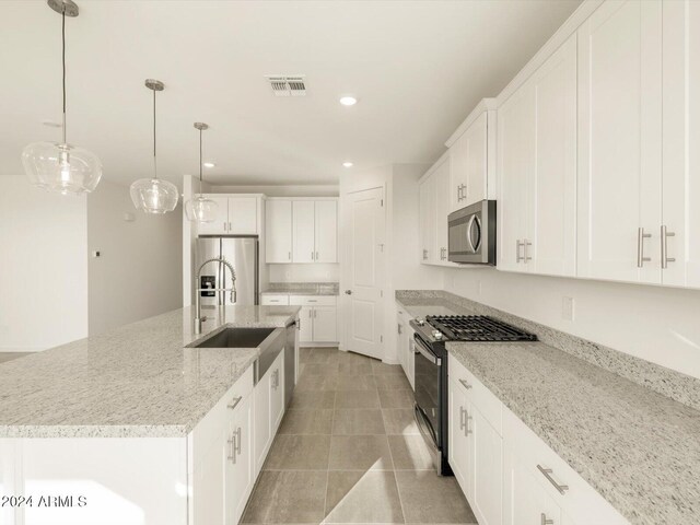 kitchen with white cabinetry, a center island with sink, pendant lighting, and appliances with stainless steel finishes