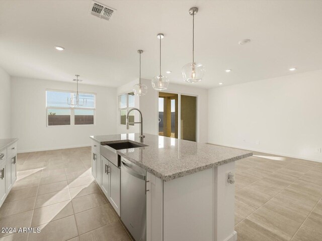 kitchen featuring sink, hanging light fixtures, stainless steel dishwasher, a kitchen island with sink, and white cabinets