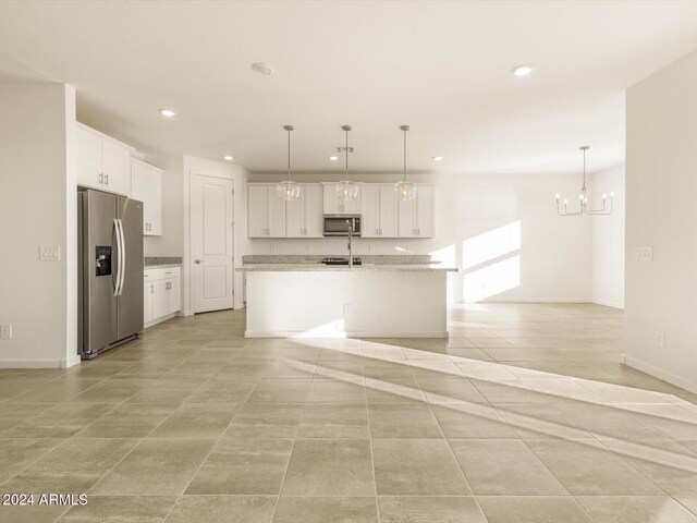 kitchen featuring decorative light fixtures, an island with sink, a notable chandelier, white cabinetry, and stainless steel appliances