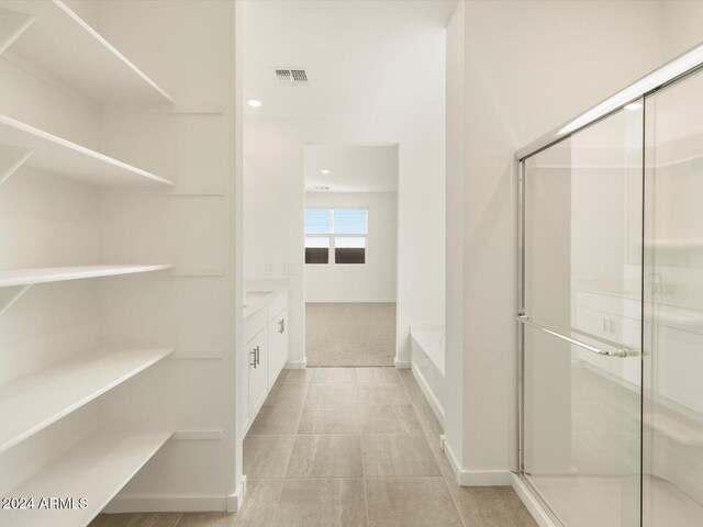 bathroom featuring vanity and independent shower and bath