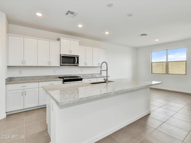 kitchen with white cabinets, sink, an island with sink, and stainless steel appliances