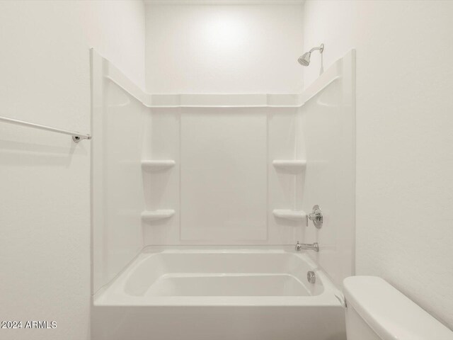 bathroom with bathtub / shower combination and toilet