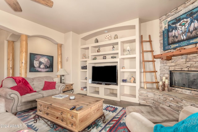 living room featuring tile patterned floors, a stone fireplace, ceiling fan, and built in features