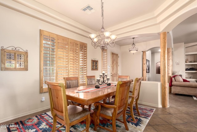 dining area with a chandelier and dark tile patterned flooring