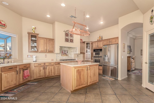 kitchen featuring appliances with stainless steel finishes, sink, a kitchen island, and a high ceiling