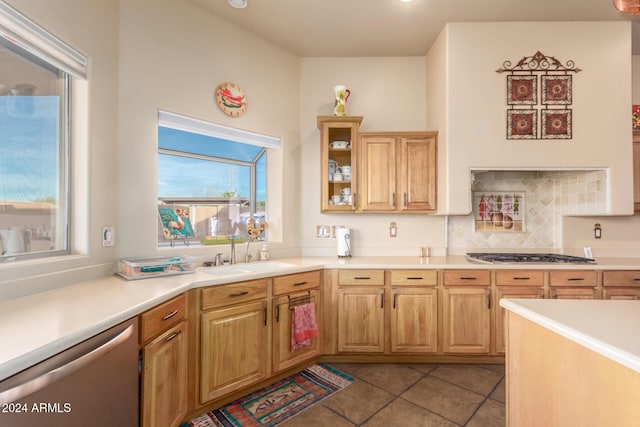 kitchen featuring backsplash, sink, light tile patterned floors, and appliances with stainless steel finishes