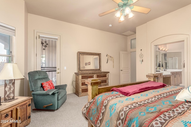 bedroom featuring ceiling fan, light colored carpet, and connected bathroom