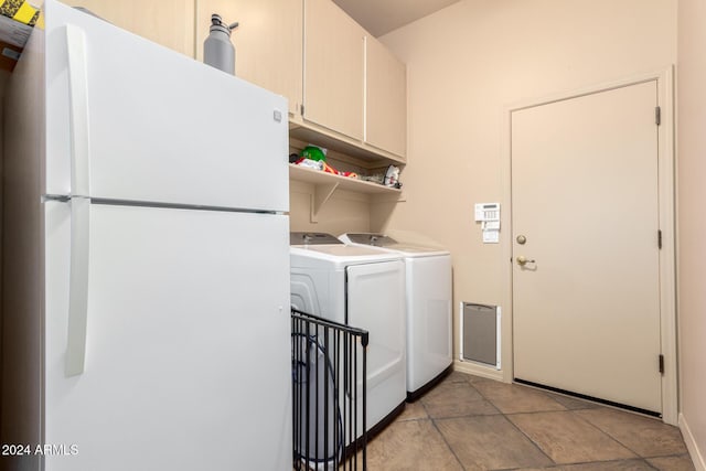 laundry area with washer and clothes dryer, light tile patterned floors, and cabinets