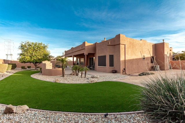 rear view of house featuring a yard and a patio