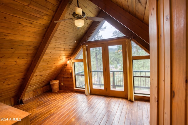 additional living space featuring a wealth of natural light, light wood-type flooring, and lofted ceiling with beams