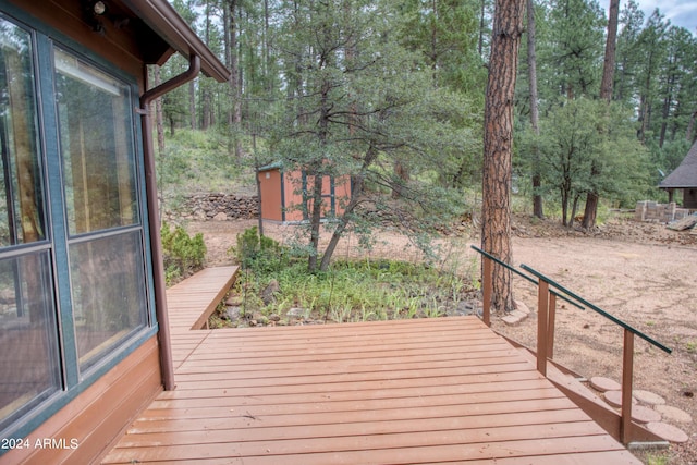 wooden deck with a shed and an outdoor structure