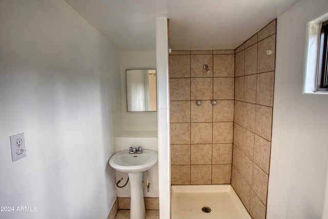 bathroom with tiled shower and sink