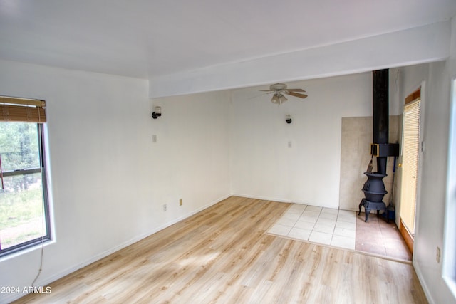 spare room featuring a ceiling fan, light wood-type flooring, and baseboards