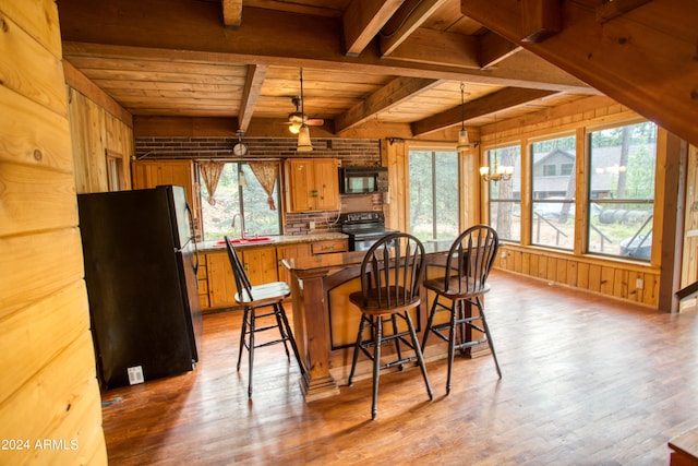 dining space with wooden ceiling, beamed ceiling, wooden walls, and hardwood / wood-style floors