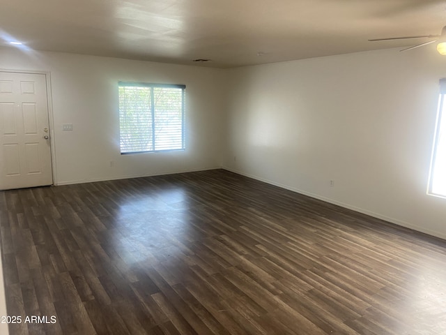 1272 W Pinkley Ave, Coolidge, AZ 85128 - empty room featuring dark wood-style flooring, a ceiling fan, and baseboards
