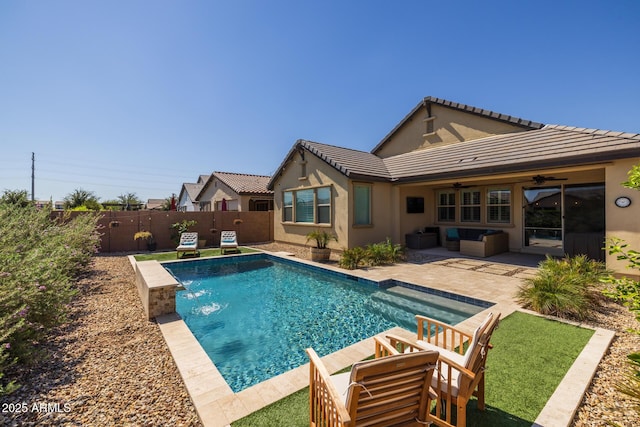 view of swimming pool with pool water feature, outdoor lounge area, ceiling fan, and a patio area