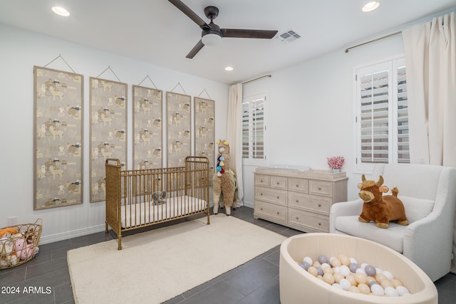 tiled bedroom with a crib and ceiling fan