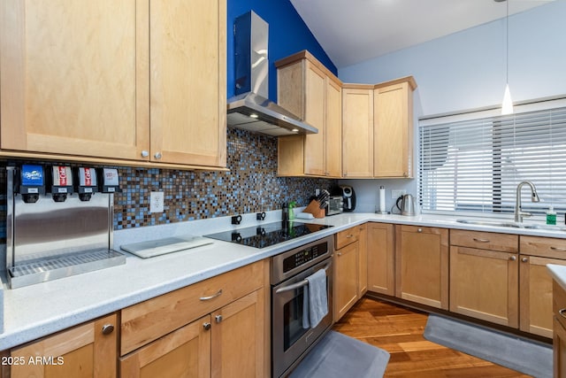 kitchen with light brown cabinetry, a sink, stainless steel oven, black electric stovetop, and wall chimney exhaust hood