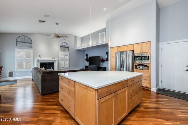 kitchen with visible vents, appliances with stainless steel finishes, a fireplace, and ceiling fan