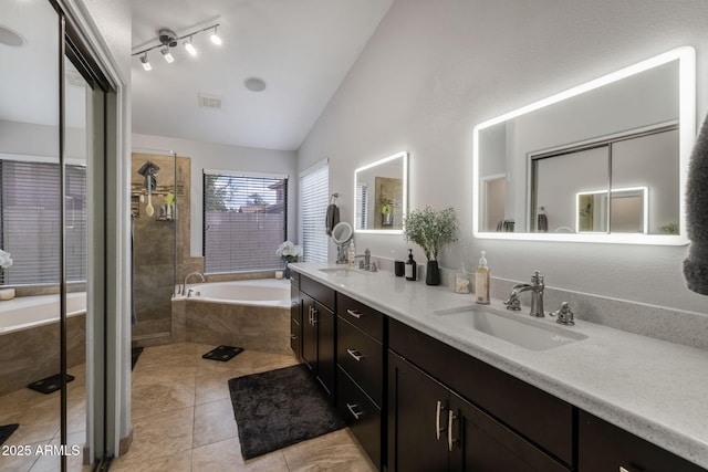 bathroom with vaulted ceiling, a garden tub, visible vents, and a sink