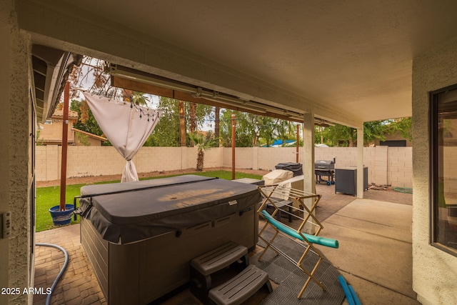 view of patio with a fenced backyard and a hot tub