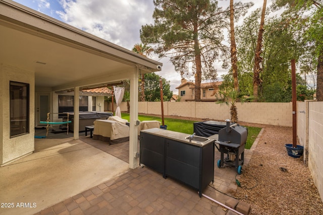 view of patio / terrace featuring a hot tub and a fenced backyard