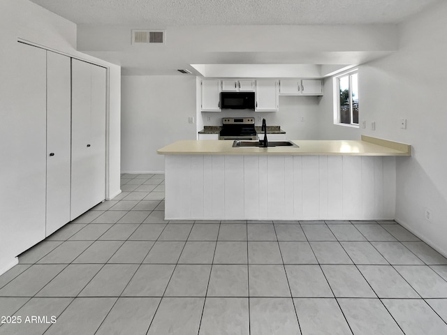 2127 W Marco Polo Rd, Phoenix, AZ 85027 - kitchen featuring black microwave, stainless steel range with electric stovetop, a sink, a peninsula, and light countertops
