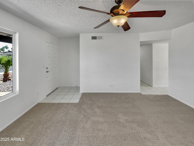 2127 W Marco Polo Rd, Phoenix, AZ 85027 - spare room featuring ceiling fan, light carpet, light tile patterned floors, and a textured ceiling
