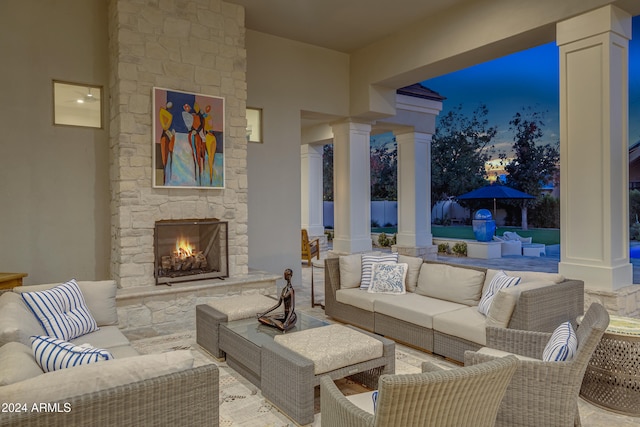 patio terrace at dusk featuring an outdoor living space with a fireplace